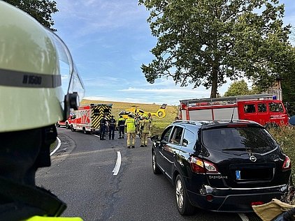 Feuerwehrmann im Vordergrund, dahinter Einsatzstelle im Verkehrsraum